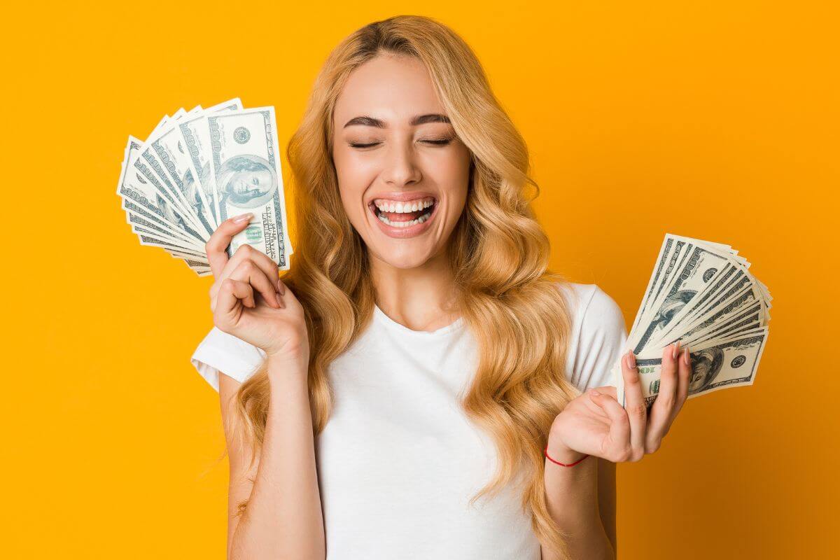 A picture of a happy woman holding money.