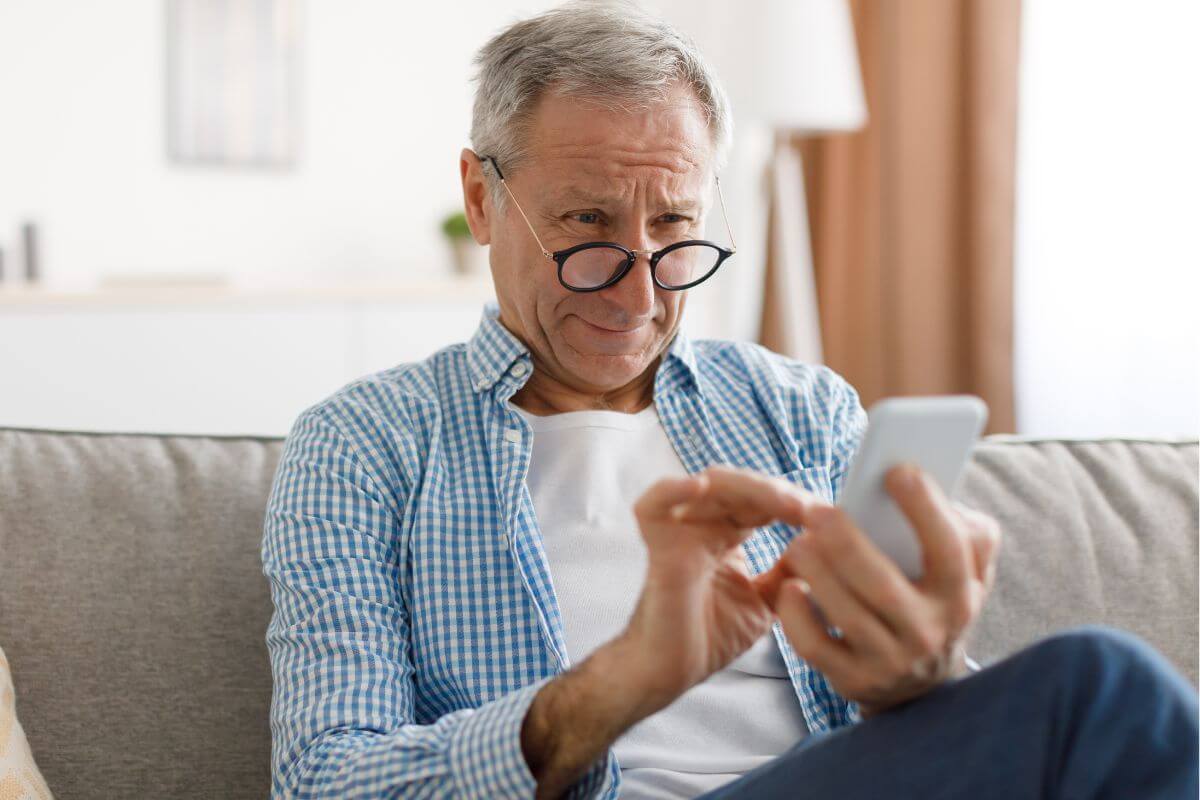 Une image d'un homme âgé utilisant un téléphone.