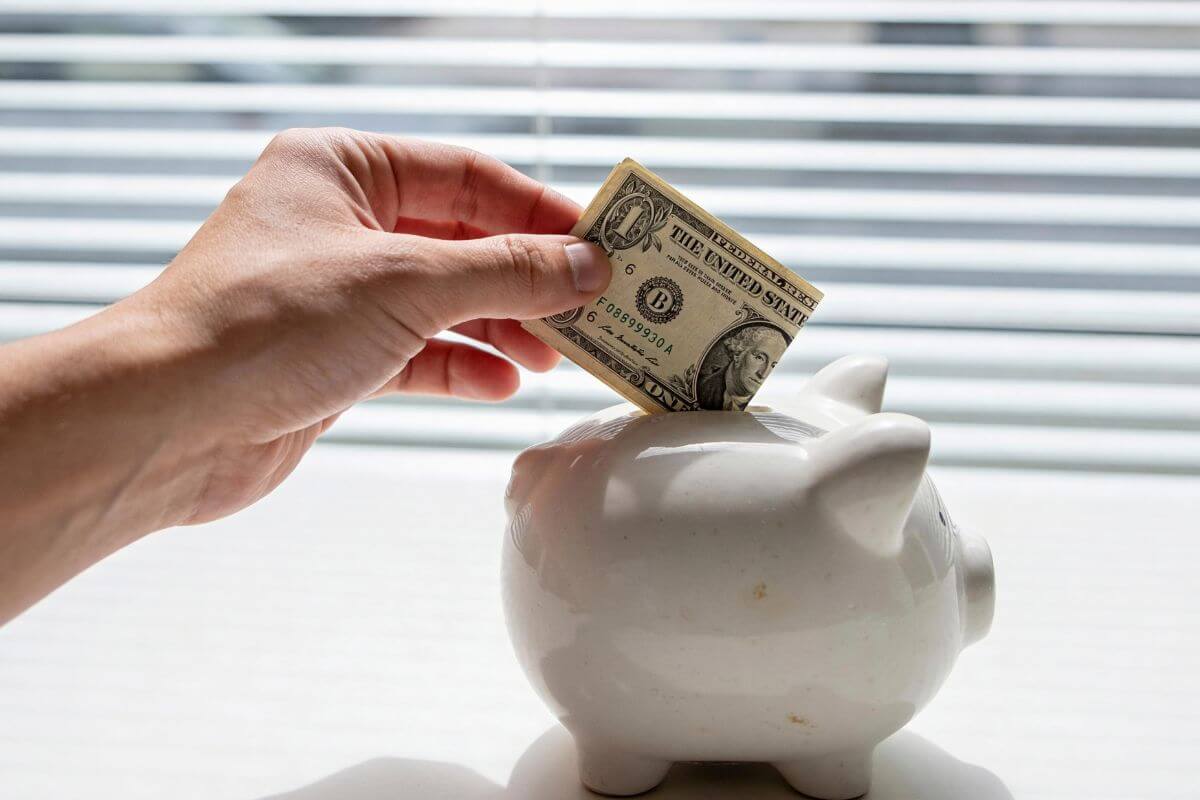 A picture shows a man's hand saving money.