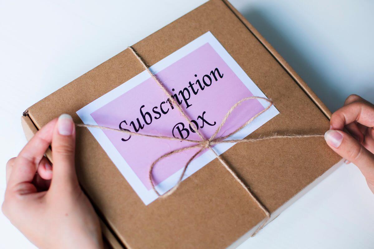 A picture shows a woman's hand unboxing the subscription box.