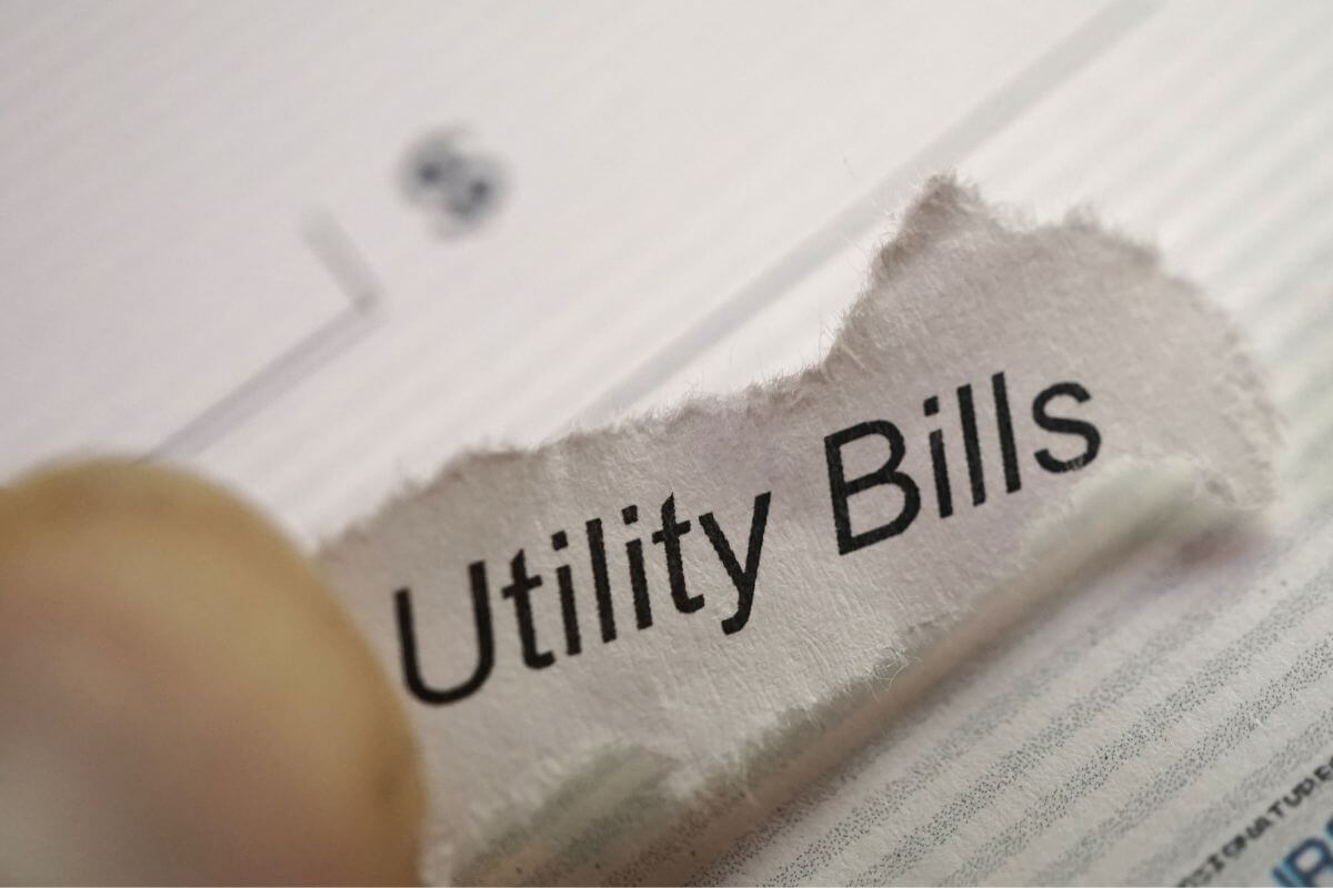 An image shows a paper with utility bills written on it.