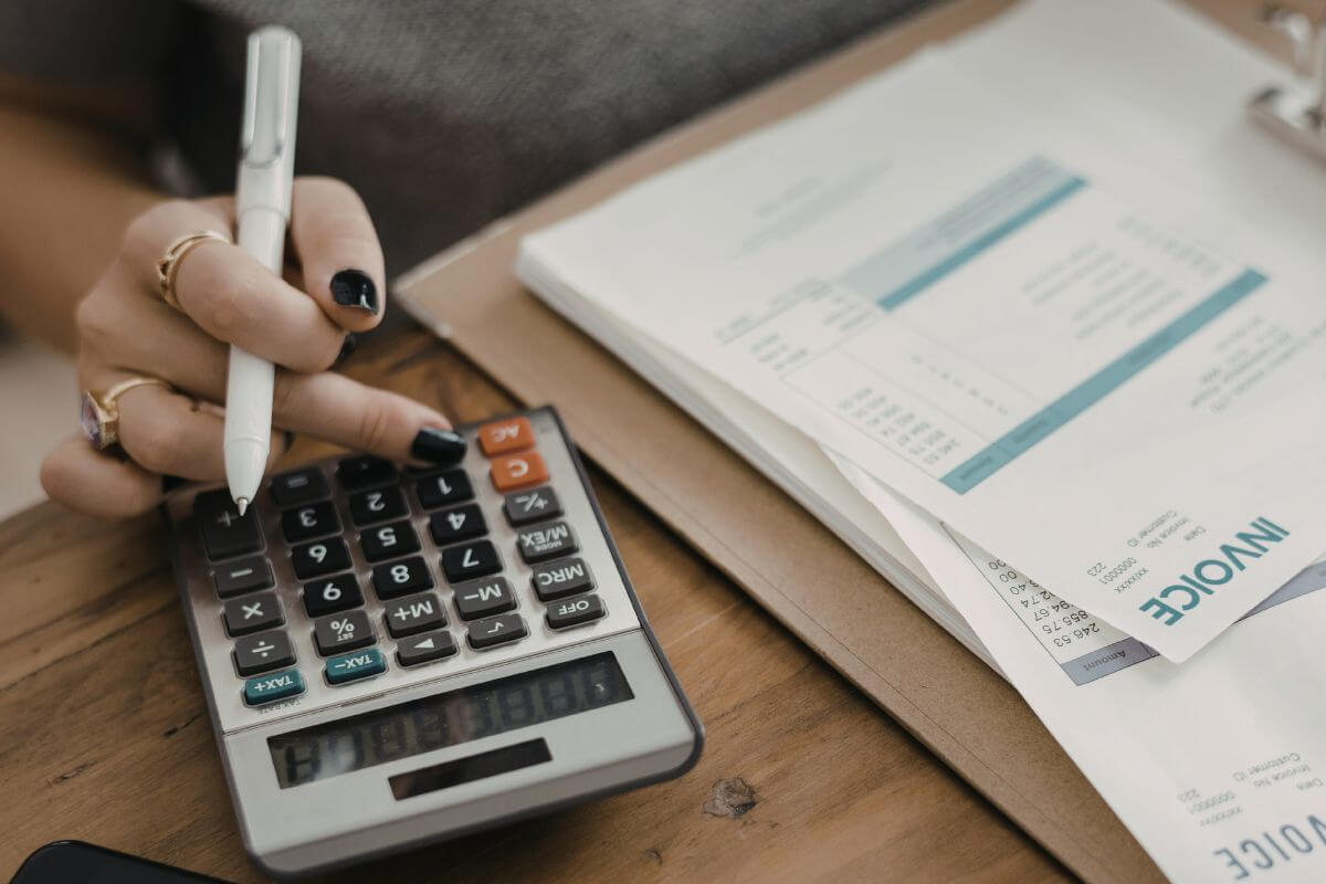A picture of a woman calculating the invoice papers.