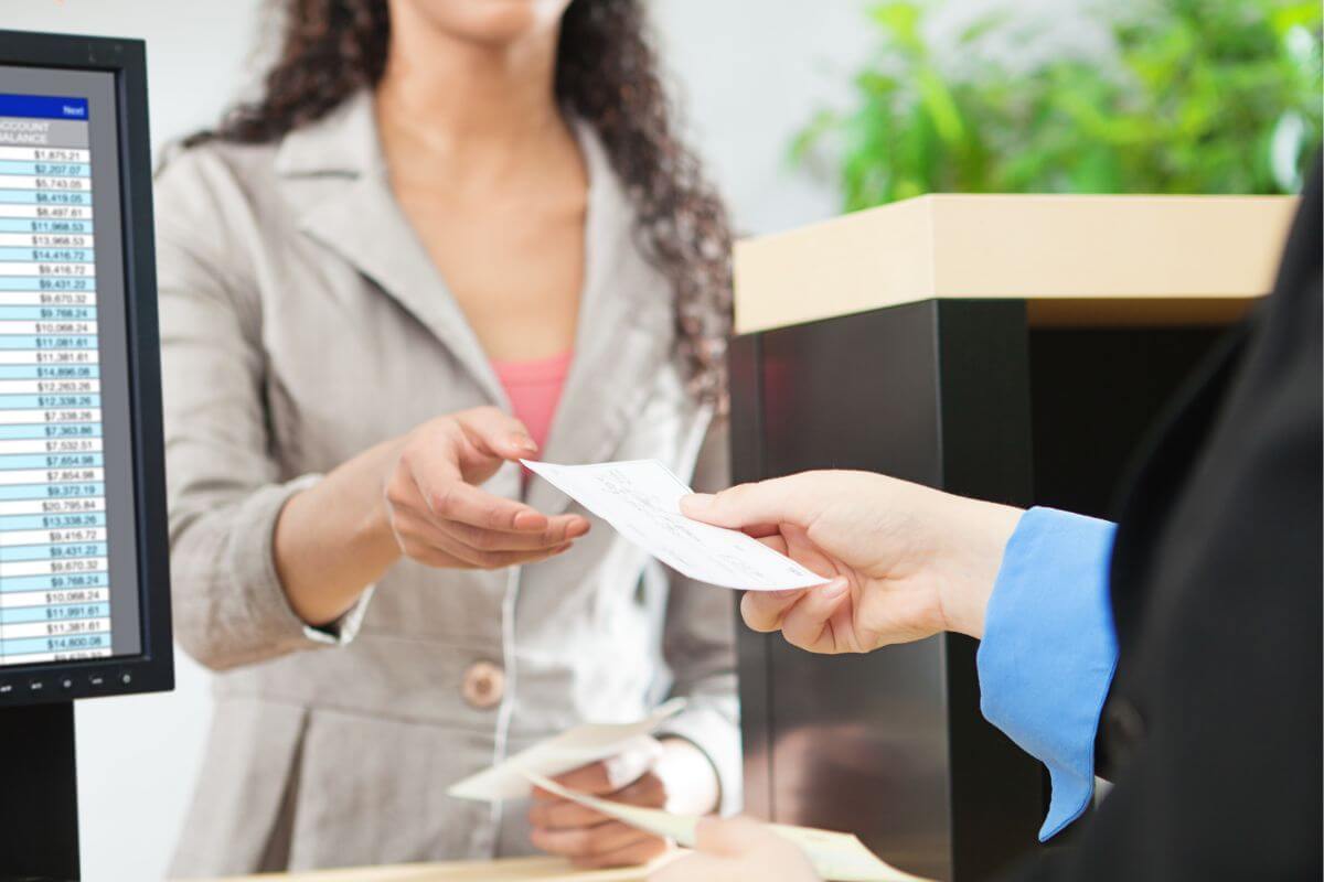 A picture of a woman having a transaction with a bank teller.