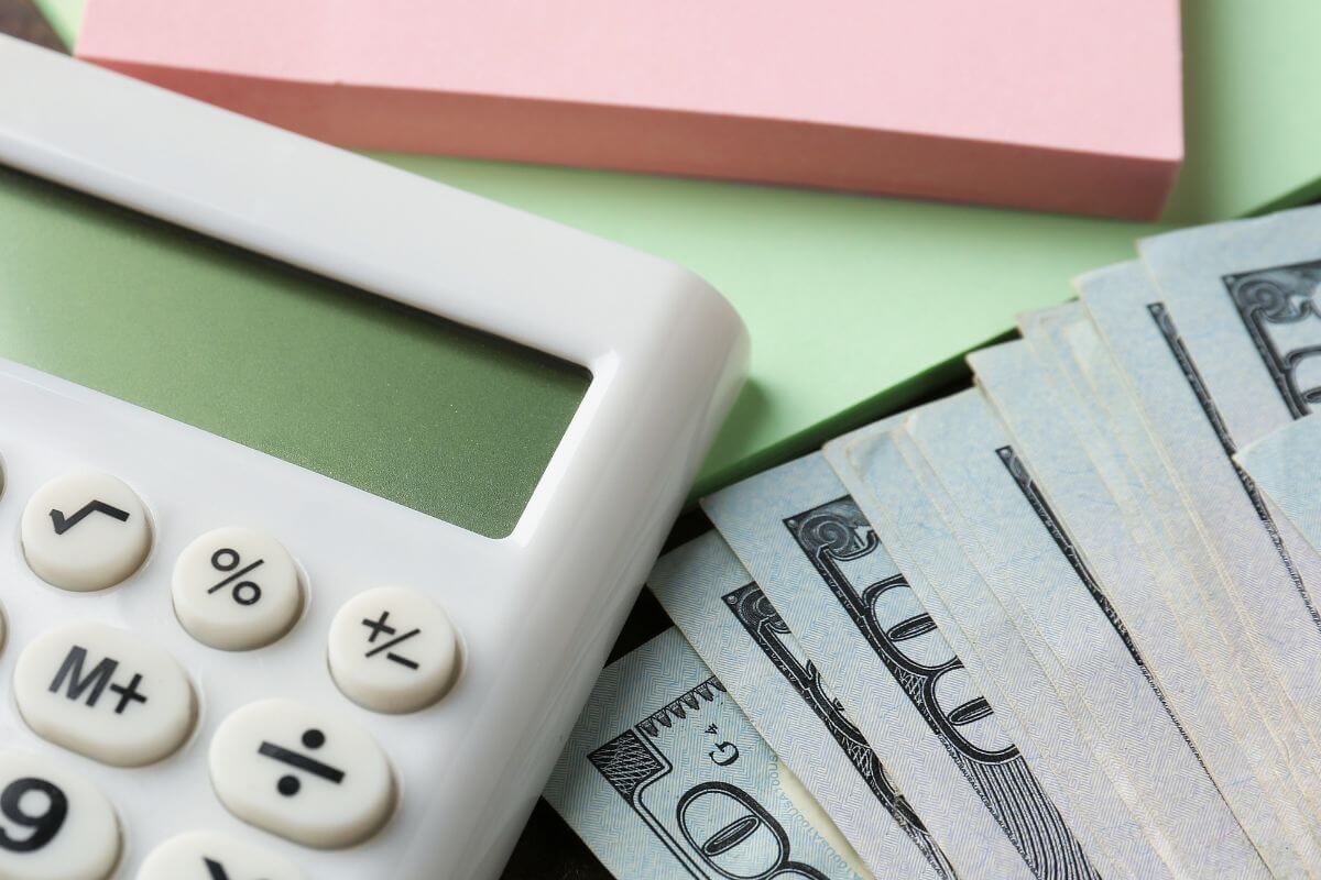 A picture shows money, a calculator, and sticker notes.