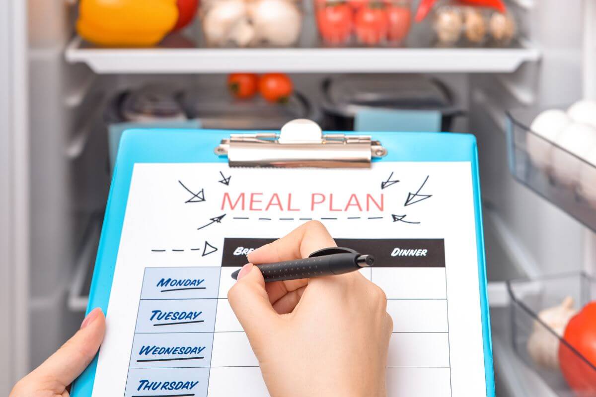 An image shows a woman making a meal plan.