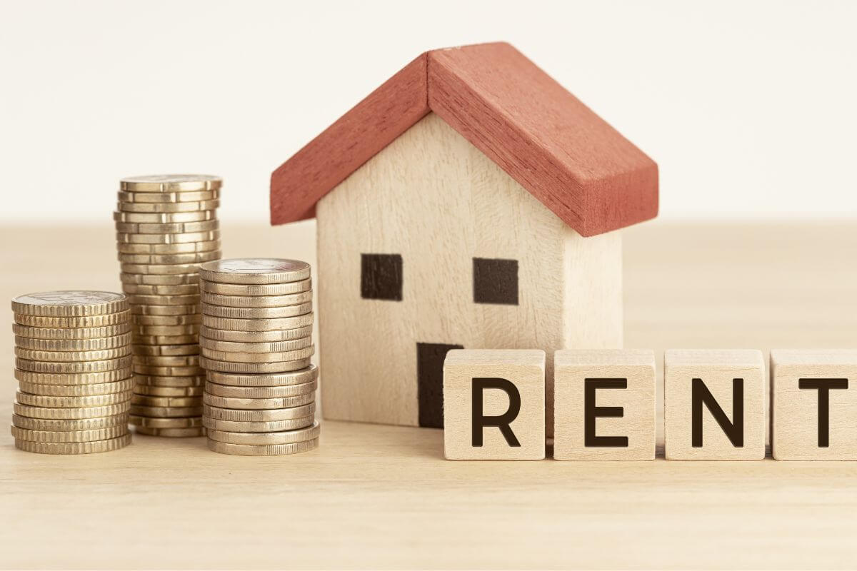A picture shows stacks of coins, a mini house, and a rent wording.