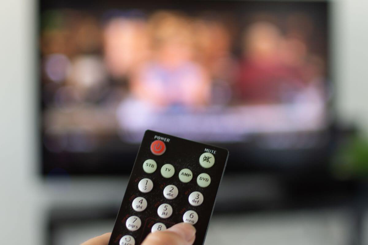 An image shows a woman watching a TV.