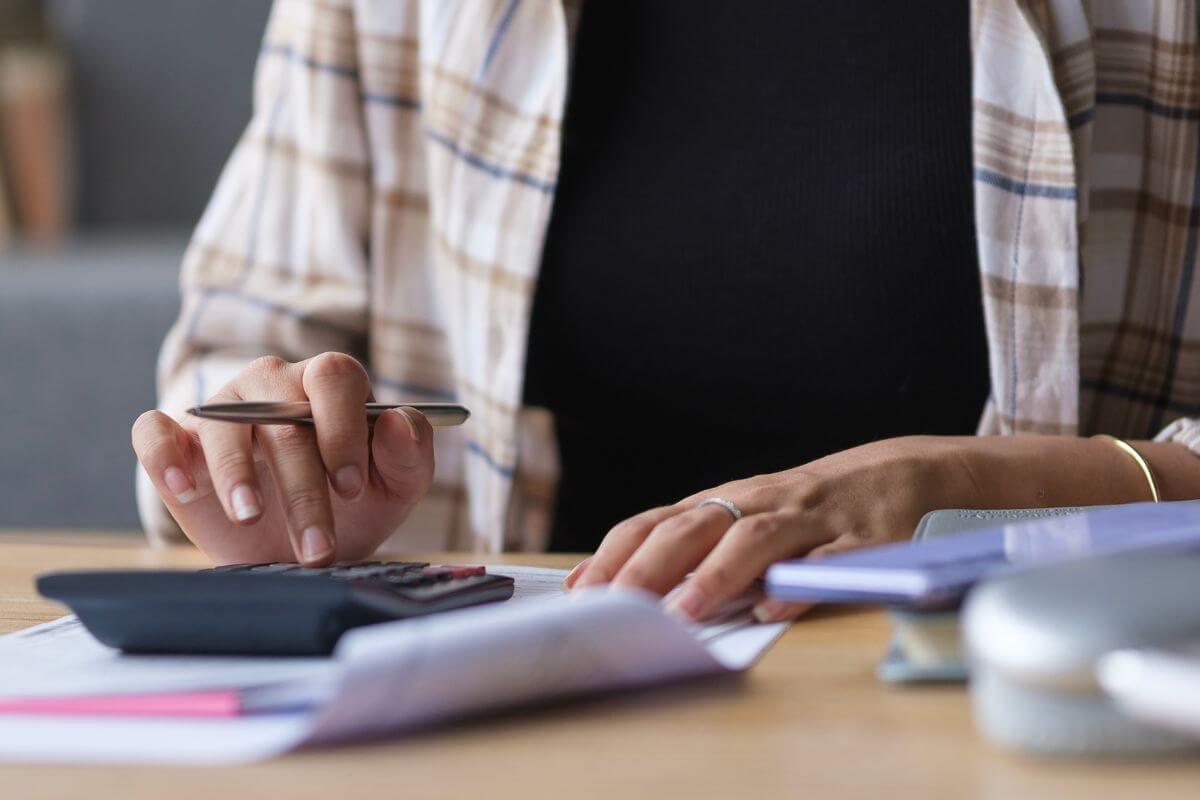 A picture of a woman calculating her expenses.