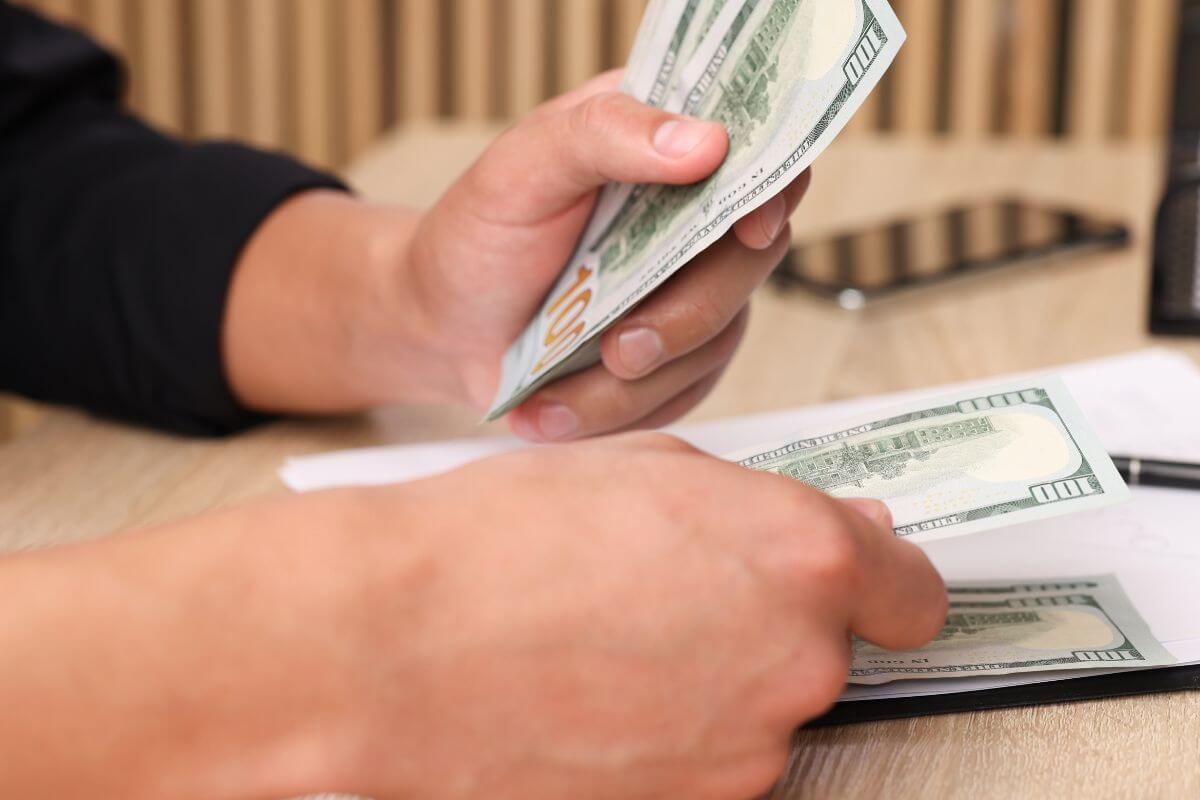 A picture of a mans hand counting money.