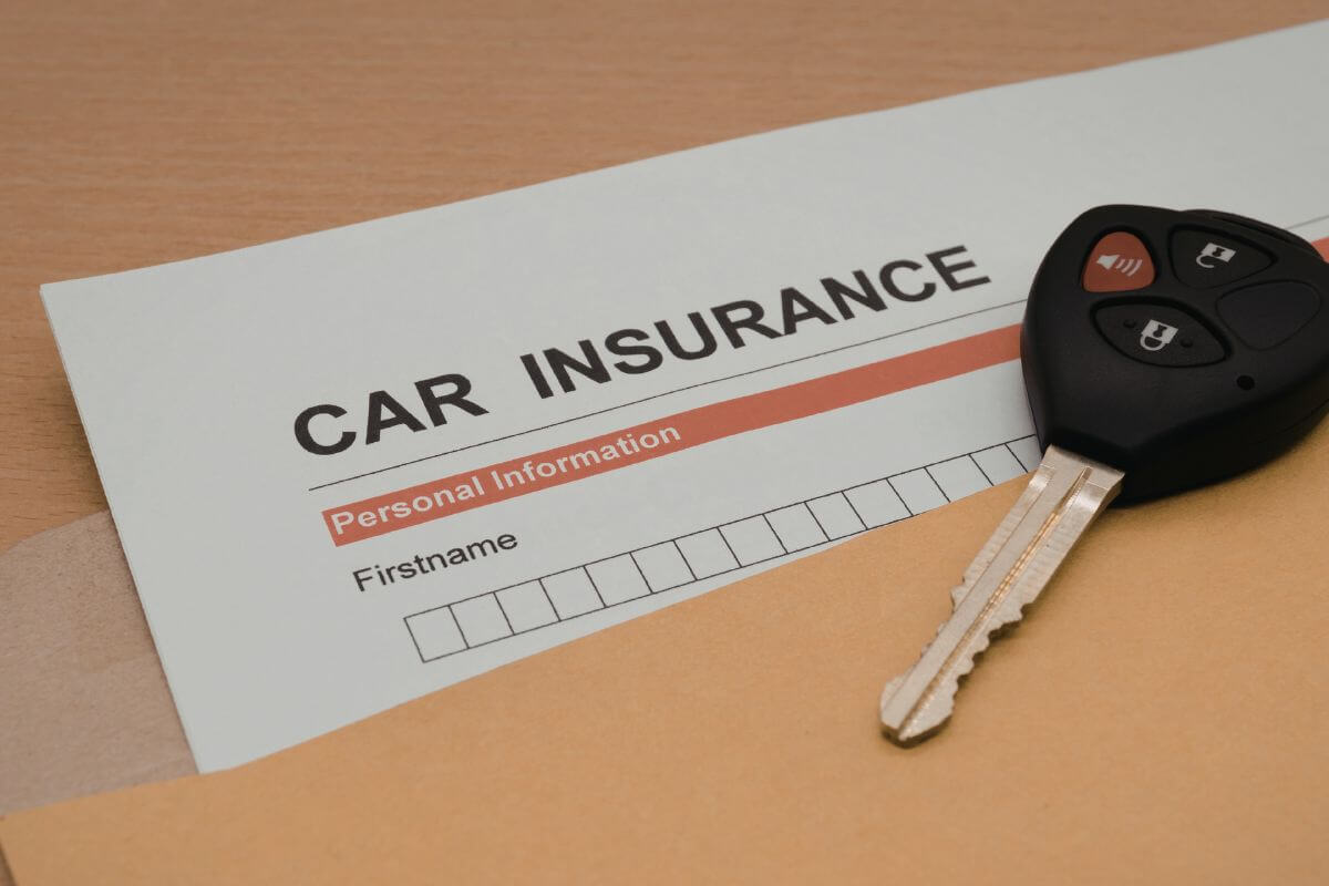 A picture of a car insurance form and a car key.