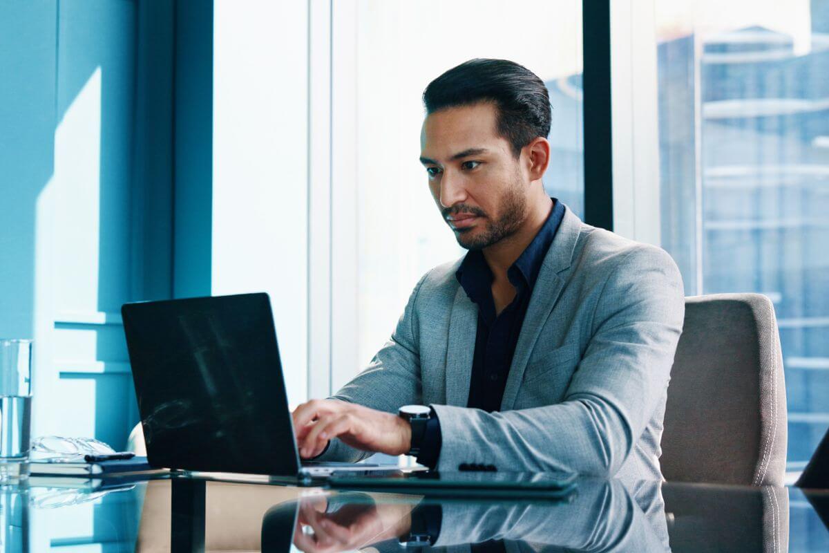 A picture of a man working on a laptop.