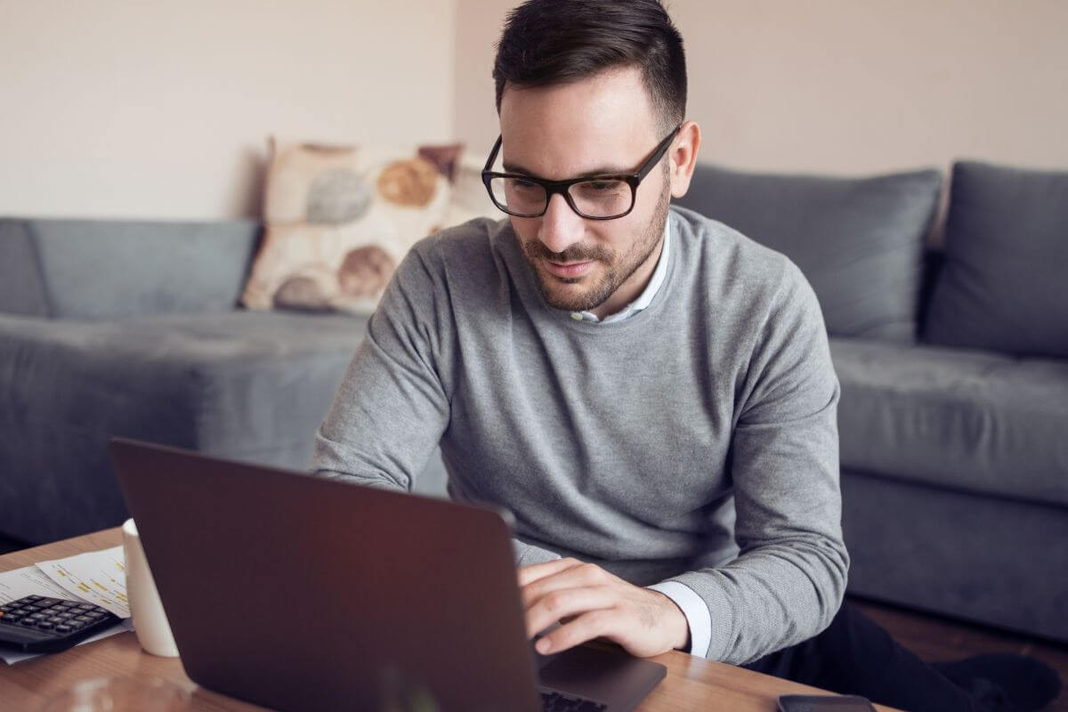 A picture of a man working on his laptop at home.