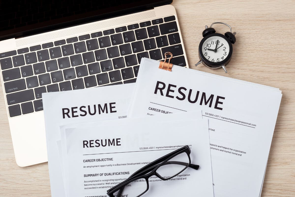 A picture shows a laptop and resume documents.