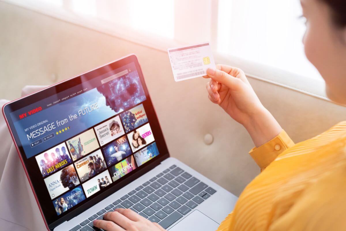 A foto de uma mulher pagando sua assinatura online.