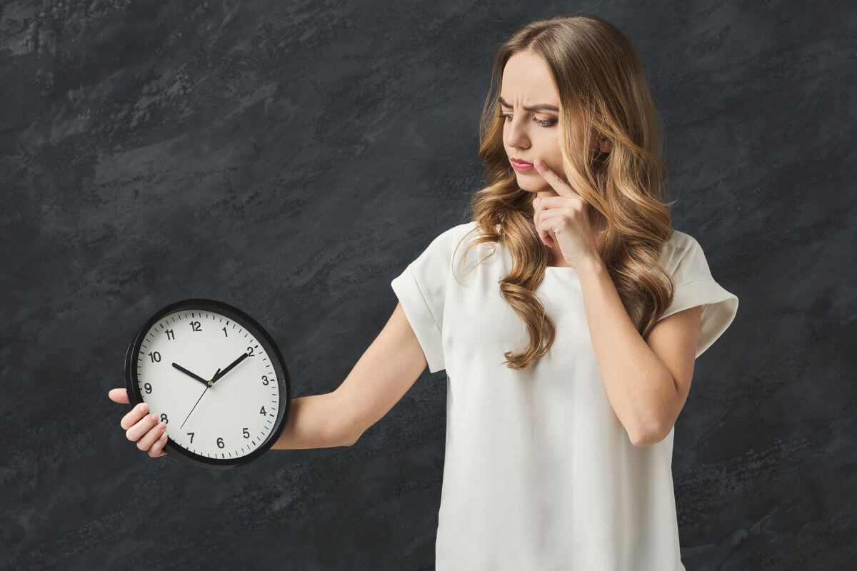 An image of a woman holding a clock.