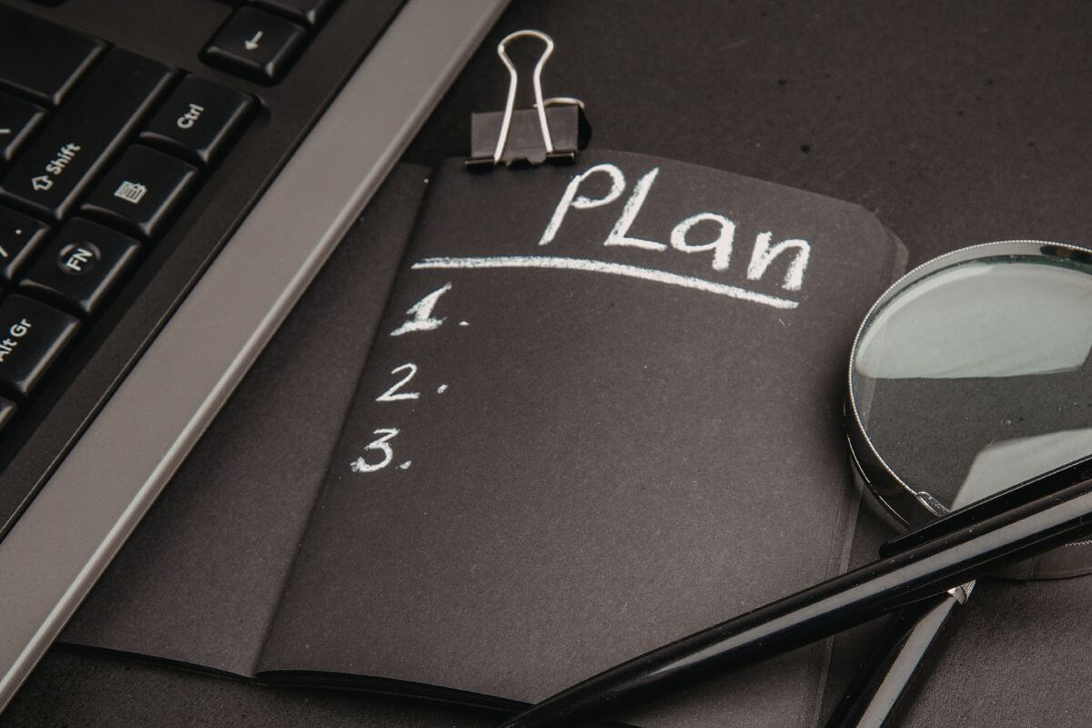 A photo shows a black notebook with a list of plans.