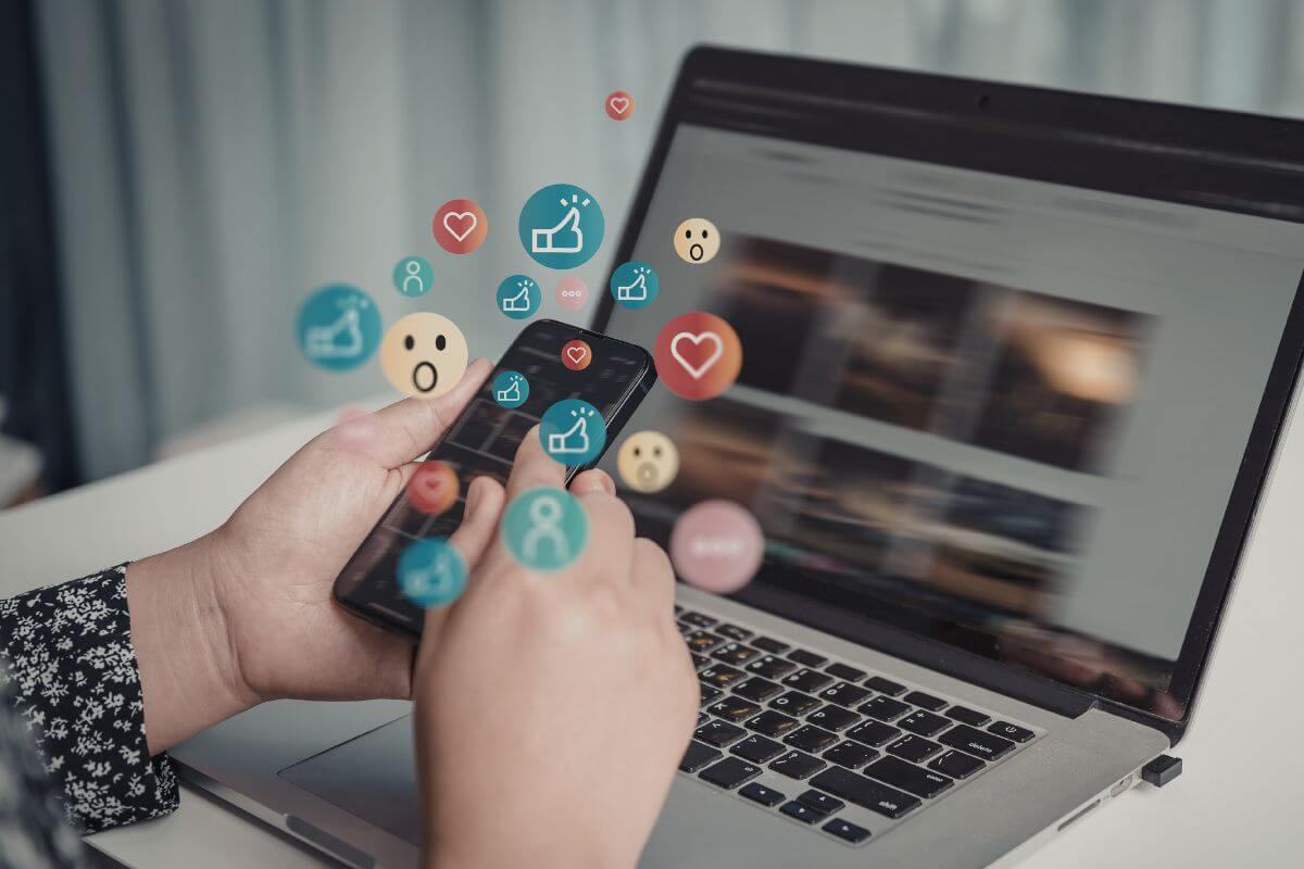 A picture shows a woman using a laptop and a phone.
