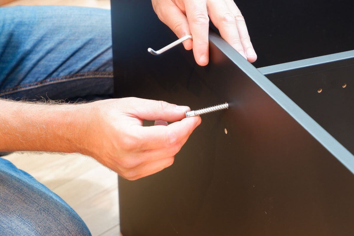 A picture of a man assembling furniture.