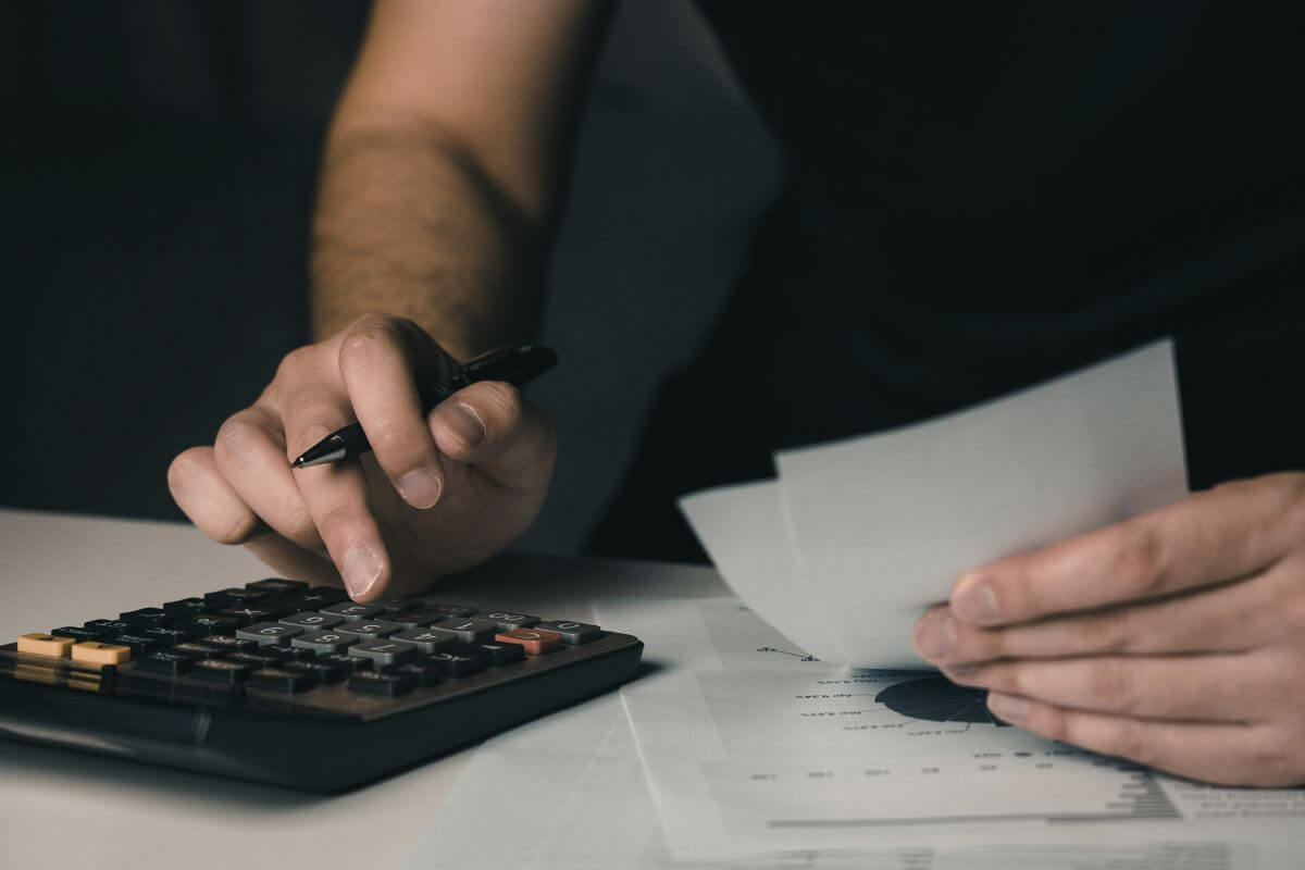An image shows a man calculating his budget.