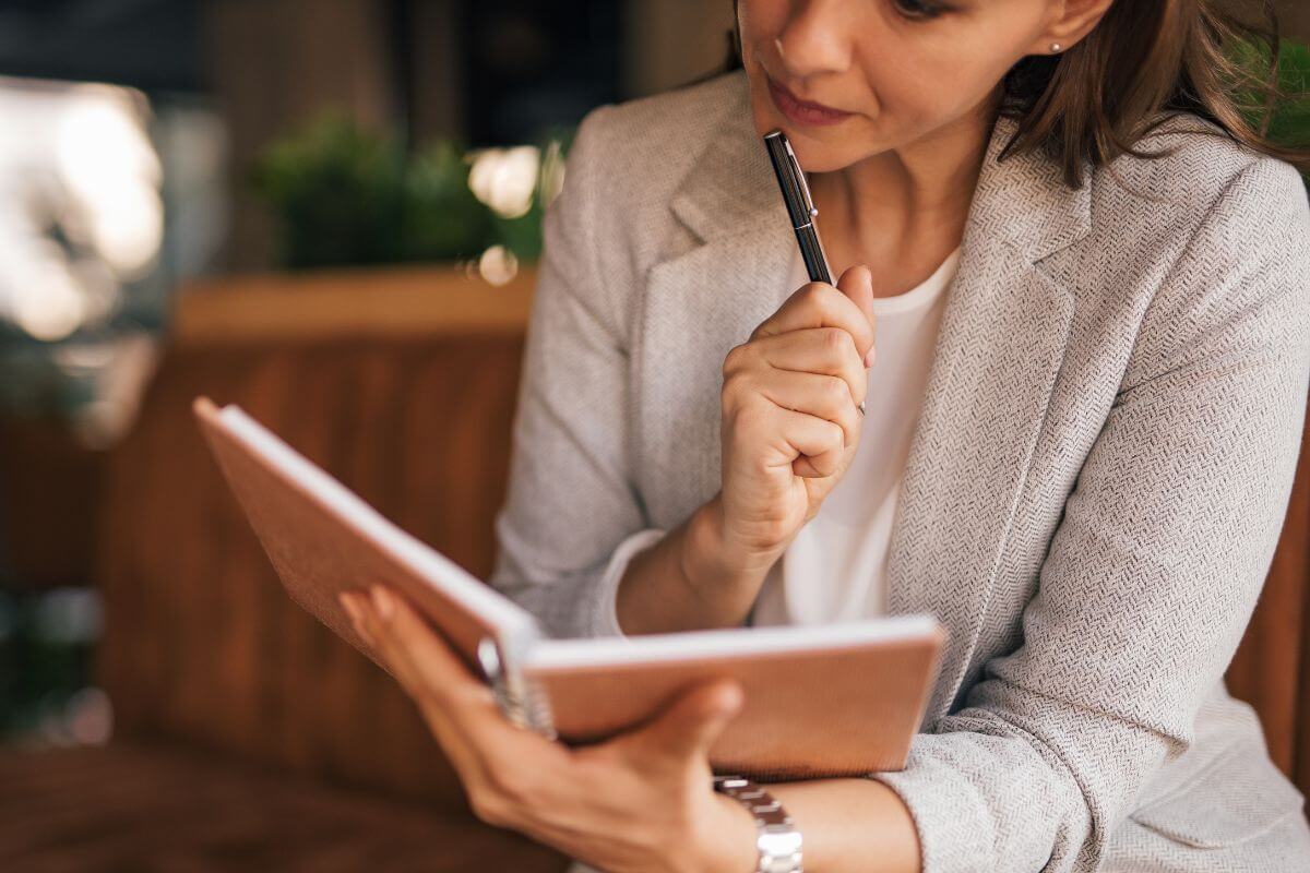 A picture of a woman checking her notebook.