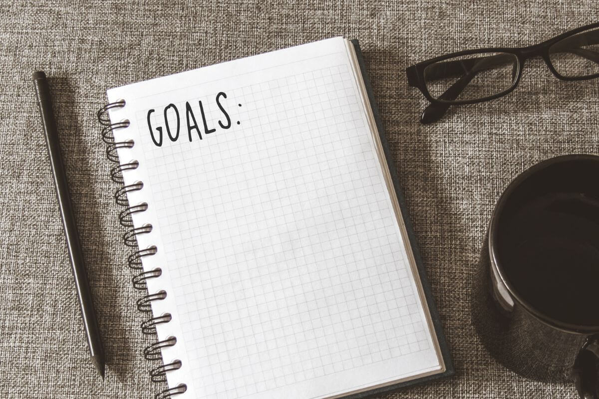 An image shows a notebook with a list of goals.