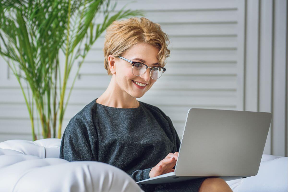 A picture shows a happy woman using a laptop.