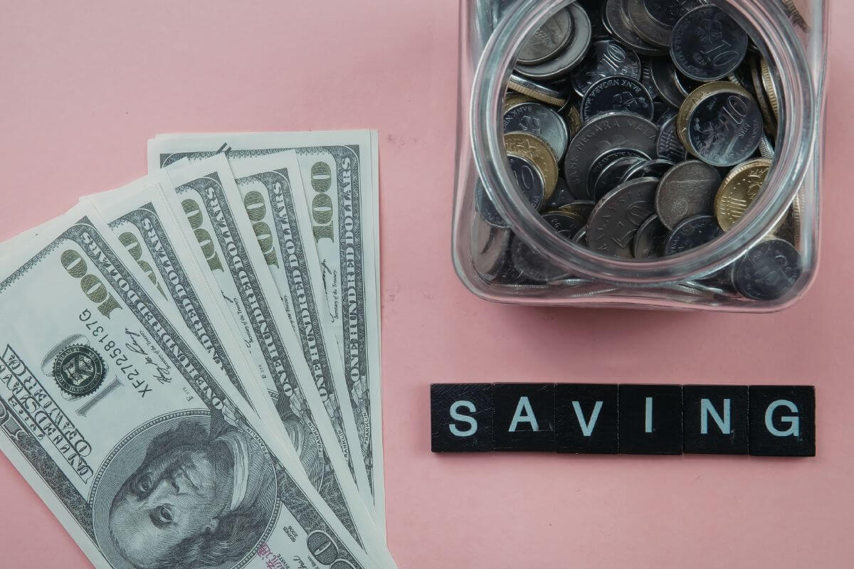 An image shows dollar bills and a jar with coins.
