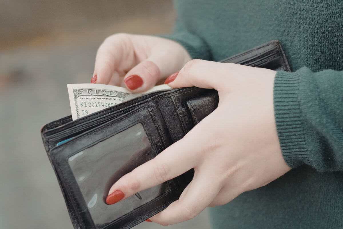 A picture of a woman putting her in her wallet.