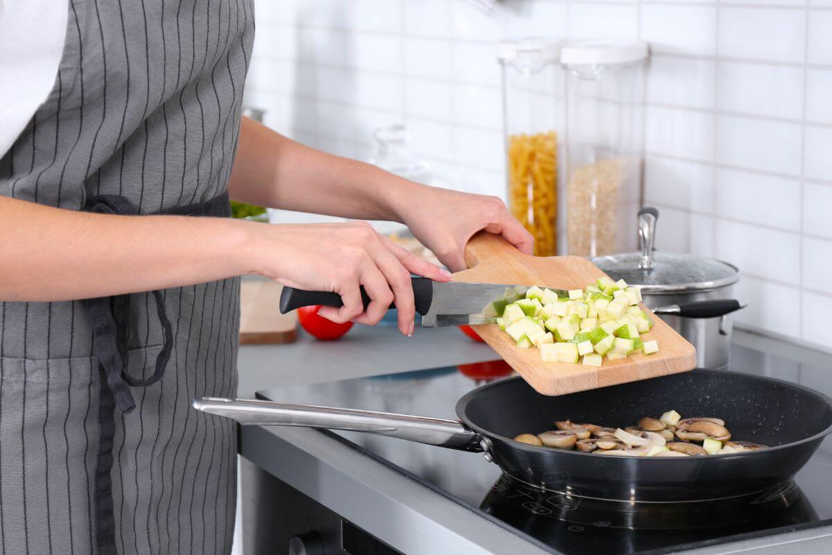 An image of a woman cooking a meal at home.