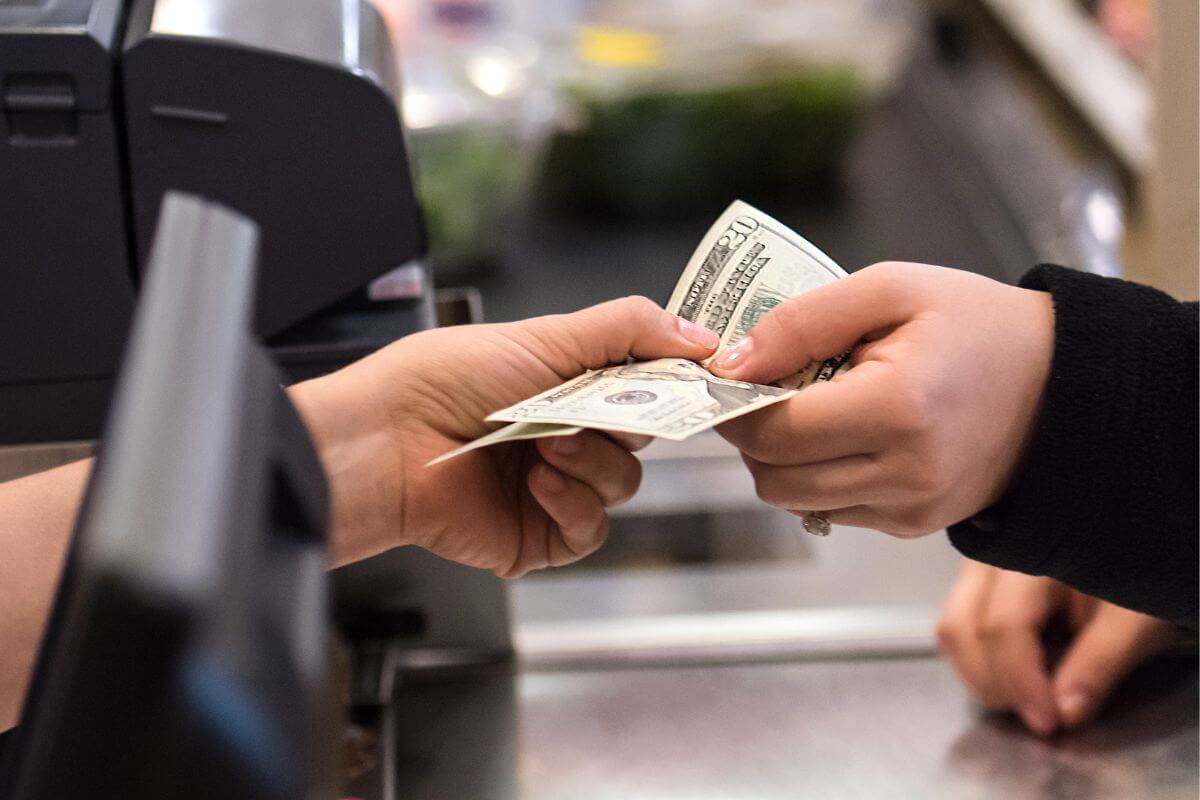 A picture shows a customer paying with cash.