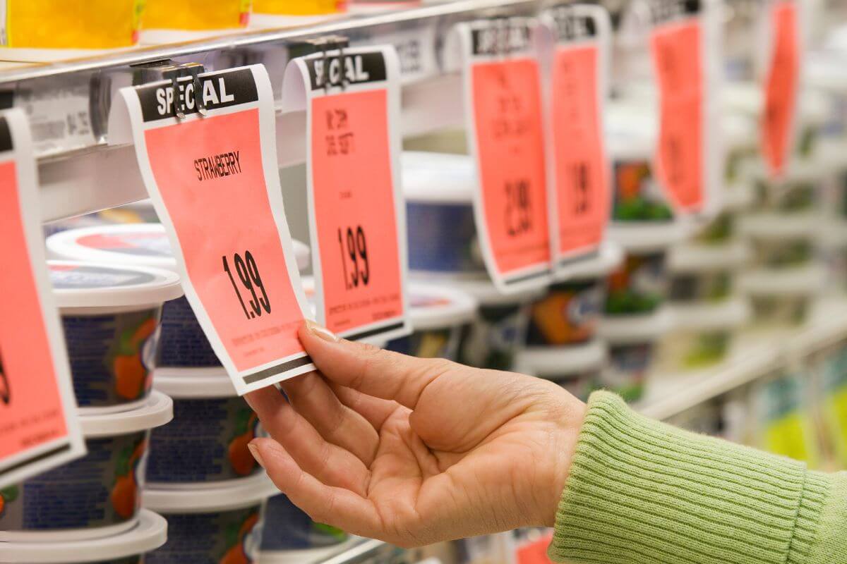 An image shows a woman's hand checking the price tag.