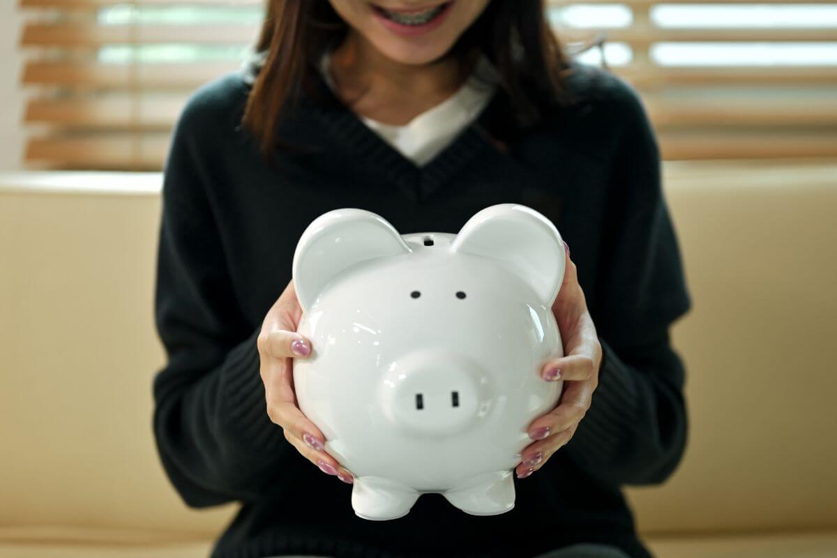 A picture shows a woman holding a piggy bank.