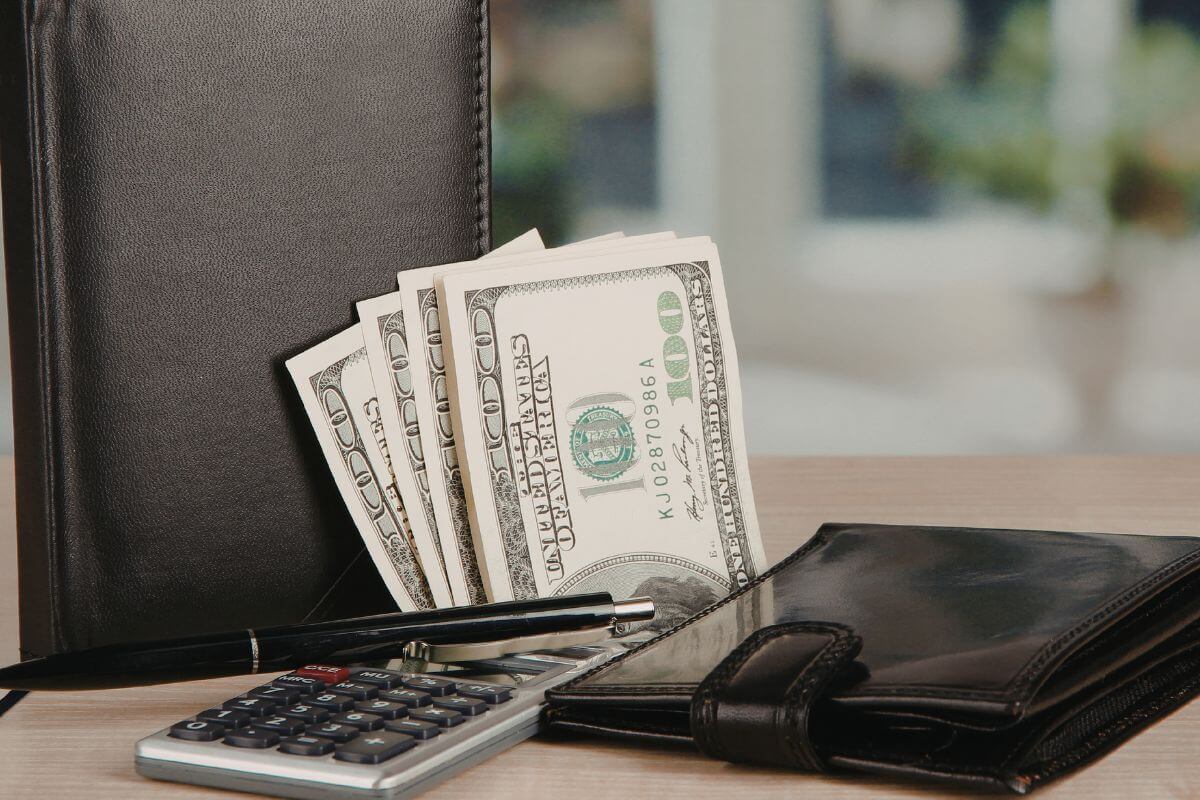 A photo shows a wallet and money on the table.