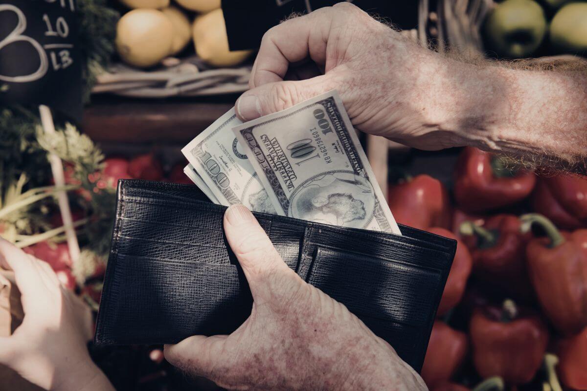 A picture shows a man's hand paying with cash.