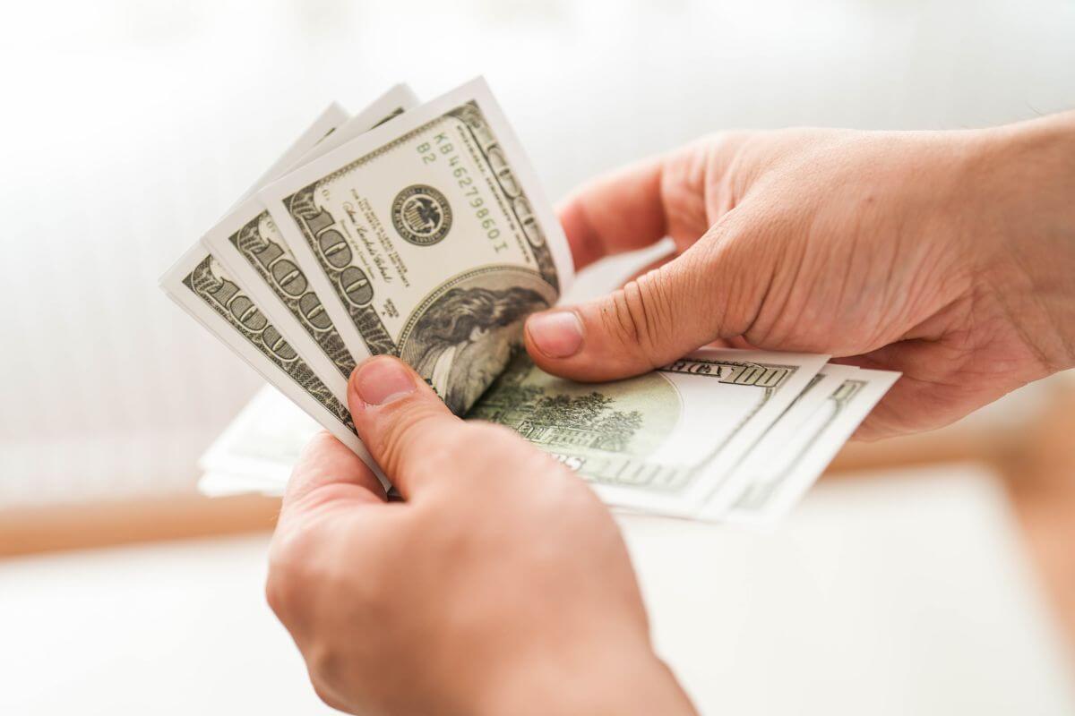 An image of a man's hand counting money.