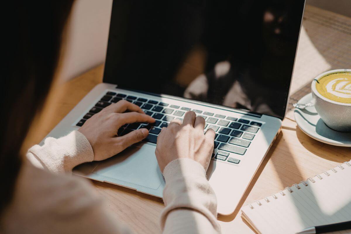 Uma foto mostra uma mulher usando um laptop.