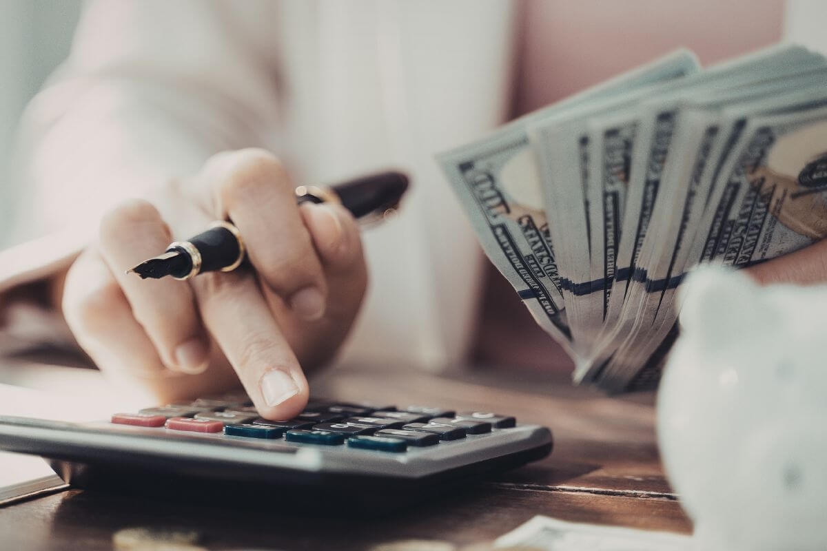 Uma foto mostra uma mulher calculando dinheiro.