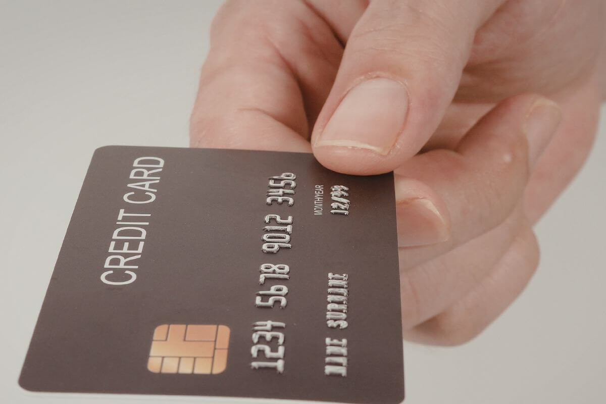 A picture of a woman's hand holding a credit card.