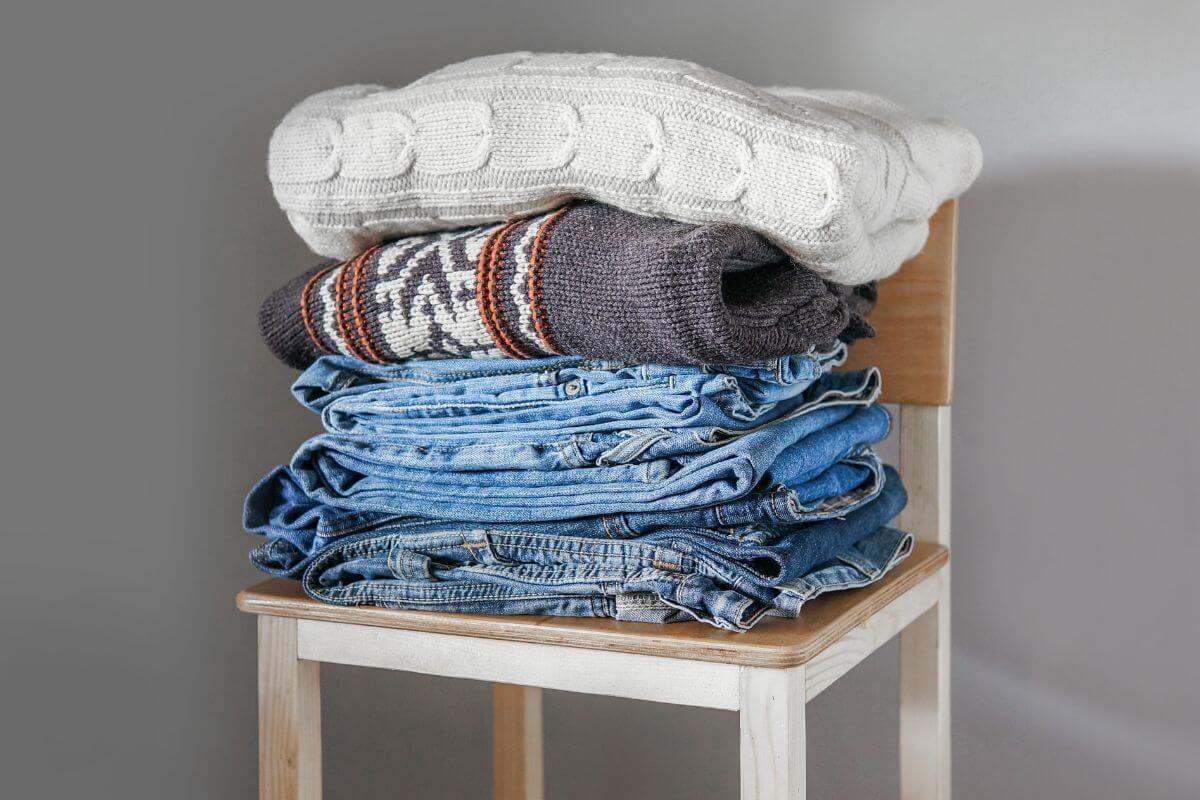 A picture shows a chair with piled clothes.