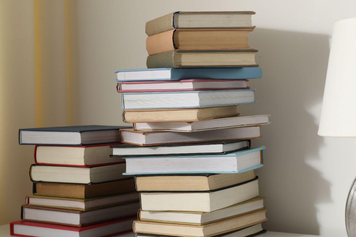 An image shows piles of books on the table.