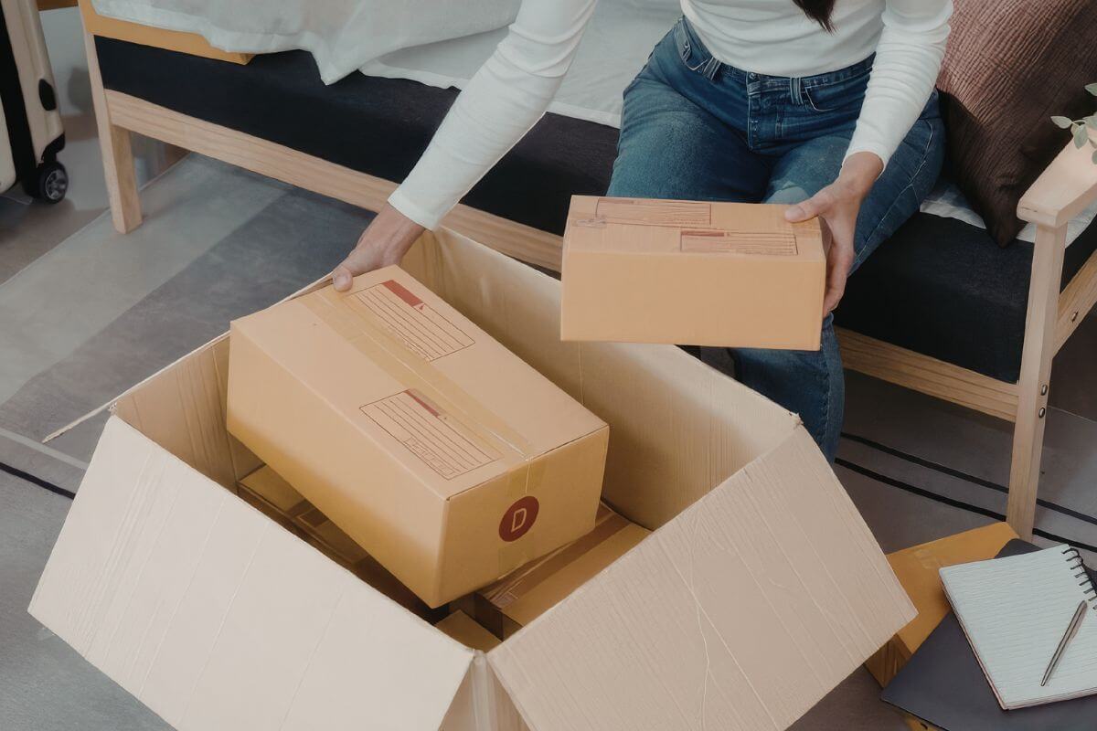 An image shows a woman packing some items.