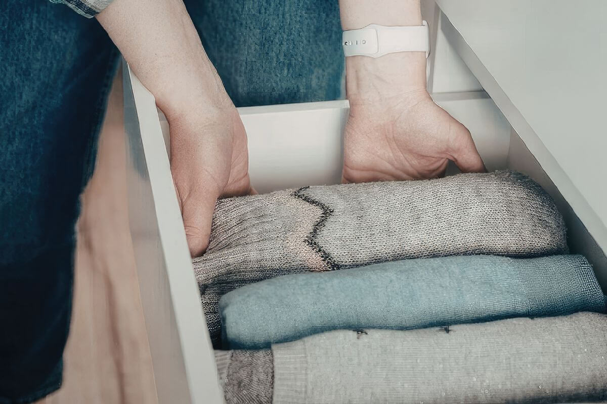 A picture of a woman organizing her clothes.