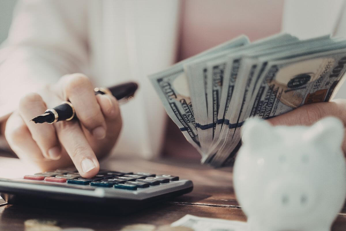 Uma imagem mostra uma mulher calculando dinheiro.