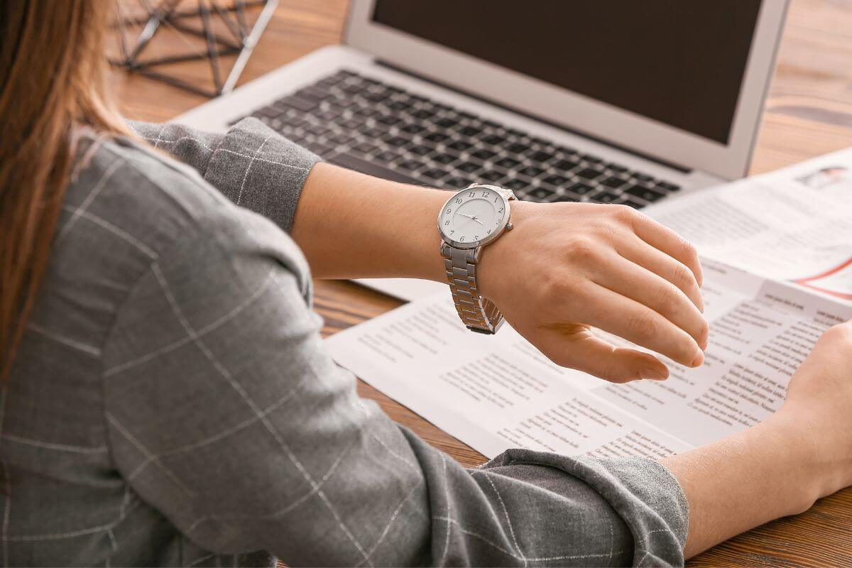 Imagem de uma mulher consultando o relógio.