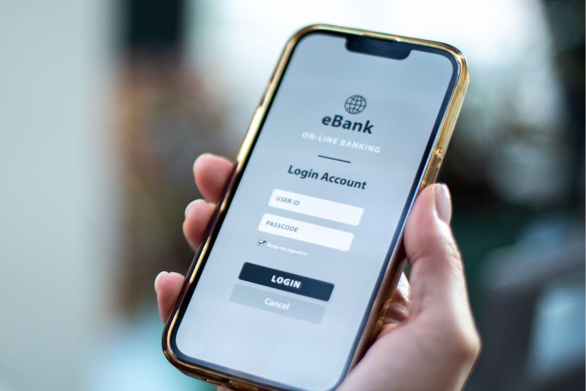 An image shows a man's hand logging in to his bank account.