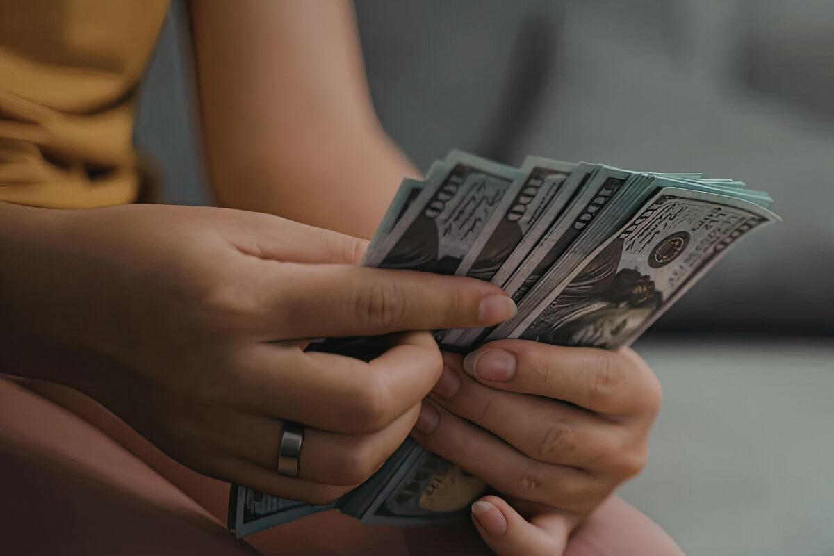 Uma foto mostra uma mulher contando dinheiro.