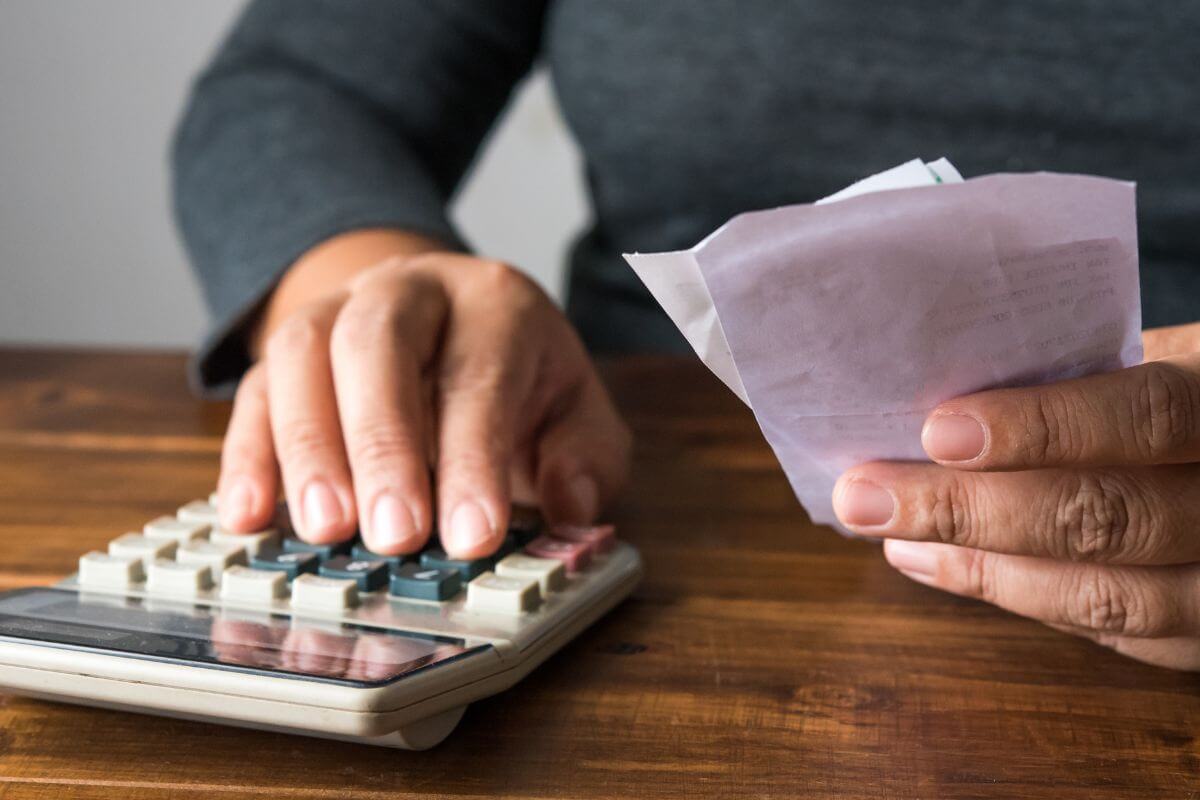 Uma foto mostra uma mulher calculando receitas.