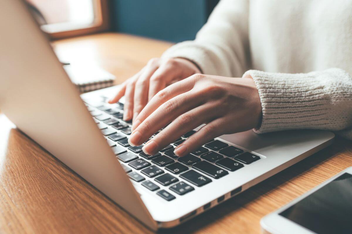 Uma foto mostra uma mulher usando um laptop.