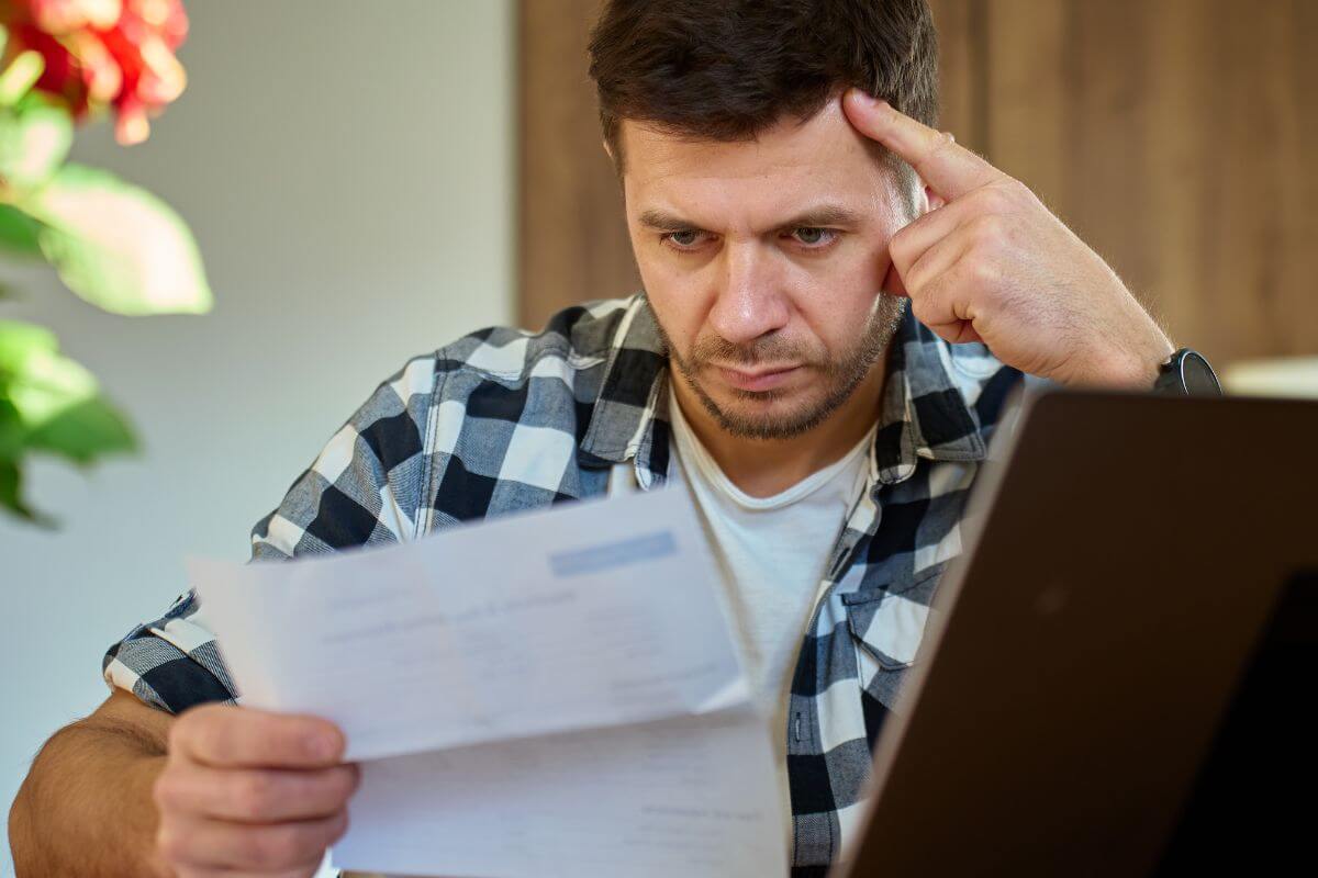 Uma foto mostra um homem revisando suas contas.